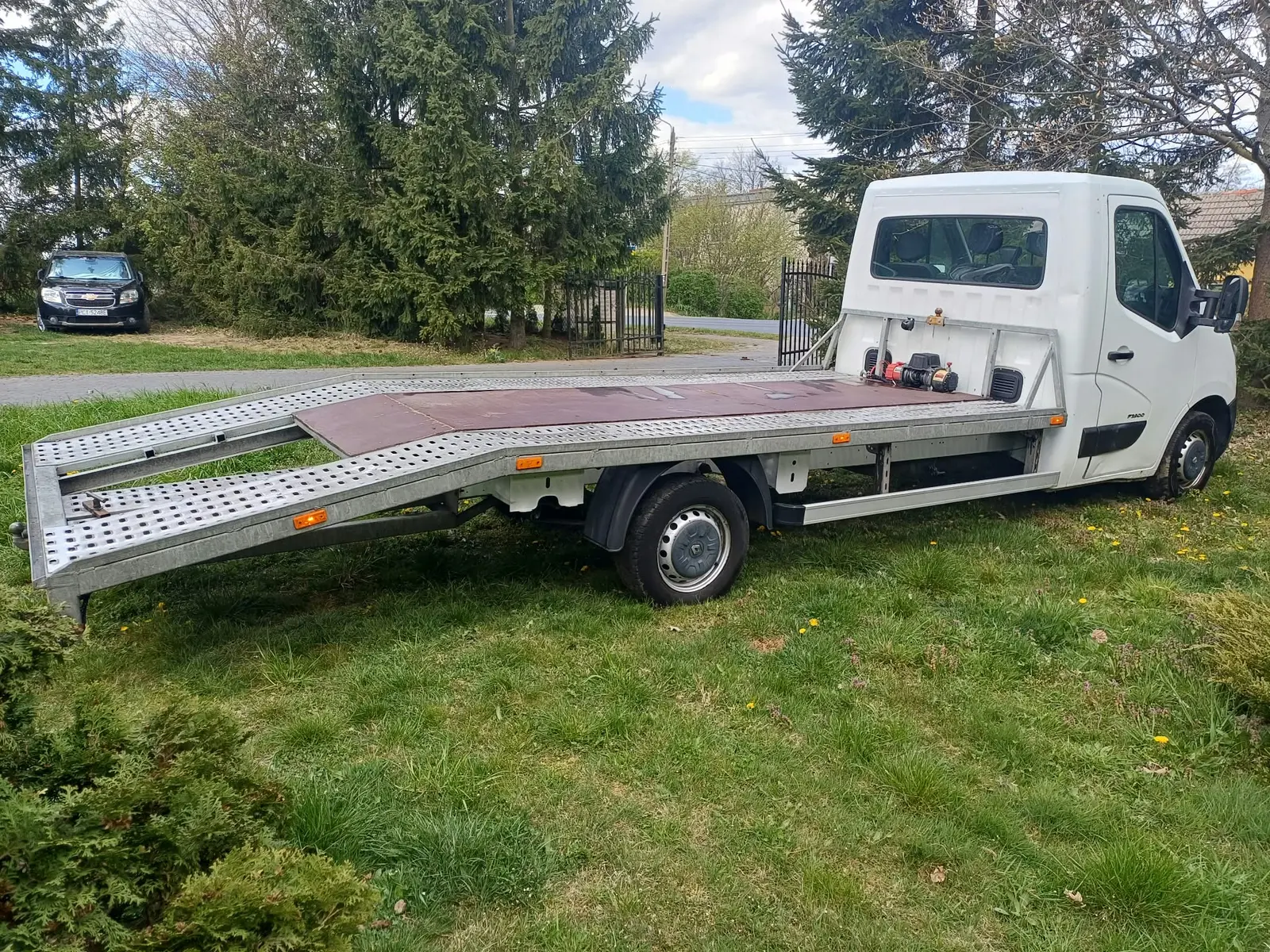 Biała autolaweta z platformą najazdową