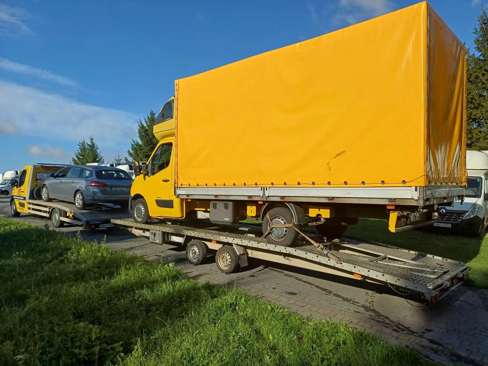 Autolaweta Tim Trans przewożąca samochód osobowy oraz samochód dostawczy na przyczepie